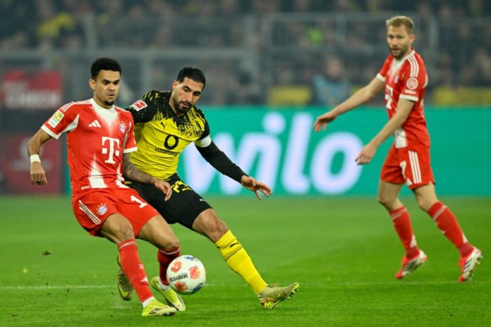 El extremo colombiano del Bayern de Múnich Luis Díaz (izda.) y el defensor alemán del Borussia Dortmund, Emre Can, pugnan por el balón durante el partido de la Bundesliga Borussia Dortmund-Bayern Múnich, en Dortmund, el 28 de febrero de 2026. AFP