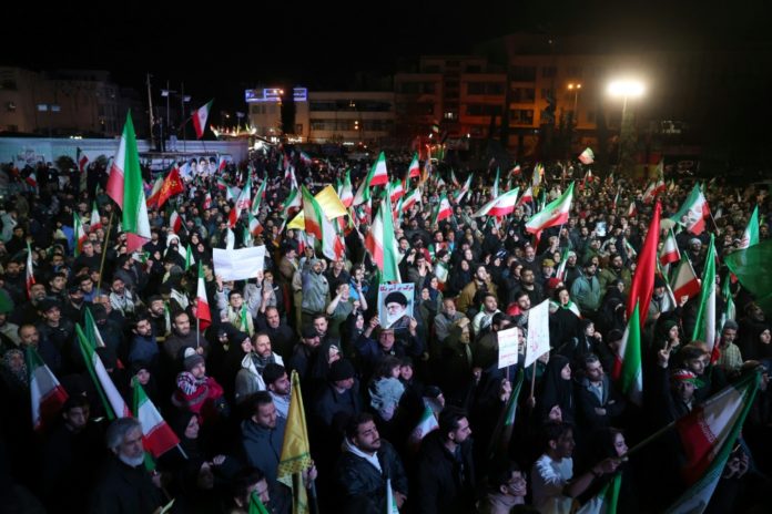 Los iraníes reaccionan tras el anuncio del alto el fuego en la Plaza de la Revolución de Teherán. AFP