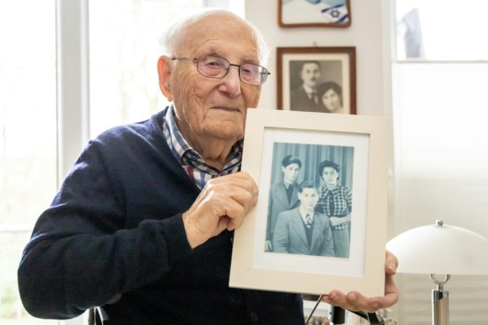 El sobreviviente del Holocausto Albrecht Weinberg muestra una fotografía en la que aparece con sus hermanos Dieter (izq.) y Friedel, el 30 de diciembre de 2024 en su casa en Leer, Alemania. AFP