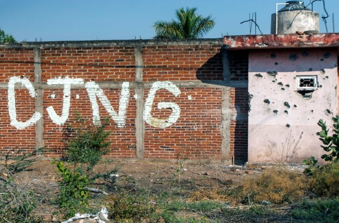 Un muro con marcas de impactos de bala y las iniciales del Cártel Jalisco Nueva Generación (CJNG), una de las dos mayores y más violentas organizaciones criminales de México, fotografiado en la comunidad de Aguililla el 23 de abril de 2021. AFP
