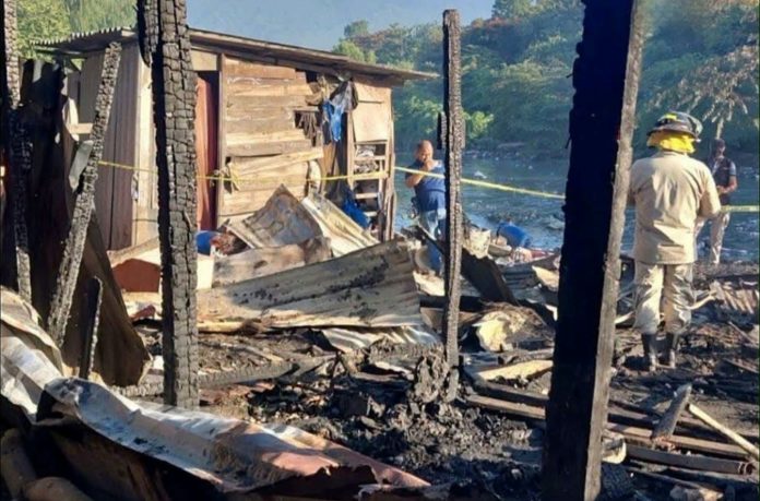 Los bomberos examinan la vivienda quemada en un barrio empobrecido de San Pedro Sula, en Honduras, el 29 de julio de 2026. AFP