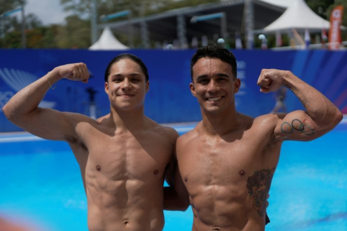 Los clavadistas mexicanos Juan Celaya (derecha) y Osmar Olvera posan tras ganar la prueba de trampolín sincronizado en los Juegos Centroamericanos y del Caribe de 2026, en Santo Domingo, el 31 de julio de 2026. AFP