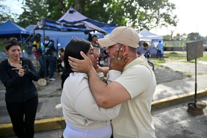 Un ex preso político se reúne con un familiar después de ser liberado afuera de la prisión El Rodeo I en Guatire, estado Miranda, Venezuela, el 14 de agosto de 2026. AFP