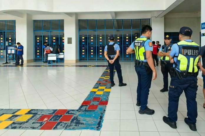 Varios policías hablan en el colegio donde se produjo el tiroteo mortal, el 18 de agosto de 2026 en Zamboanga, al sur de Filipinas. AFP