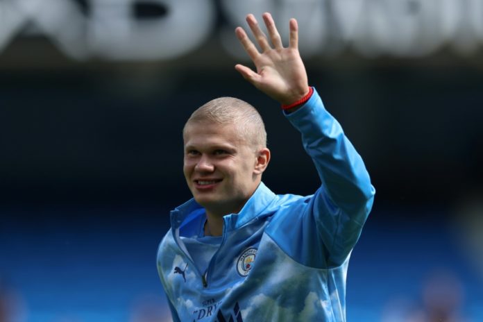 El delantero noruego del Manchester City, Erling Haaland, saluda con su nuevo corte de pelo durante el calentamiento previo al partido de la Premier League Manchester City-AFC Bournemouth, en el Etihad Stadium de Mánchester, Inglaterra, el 23 de agosto de 2026. AFP