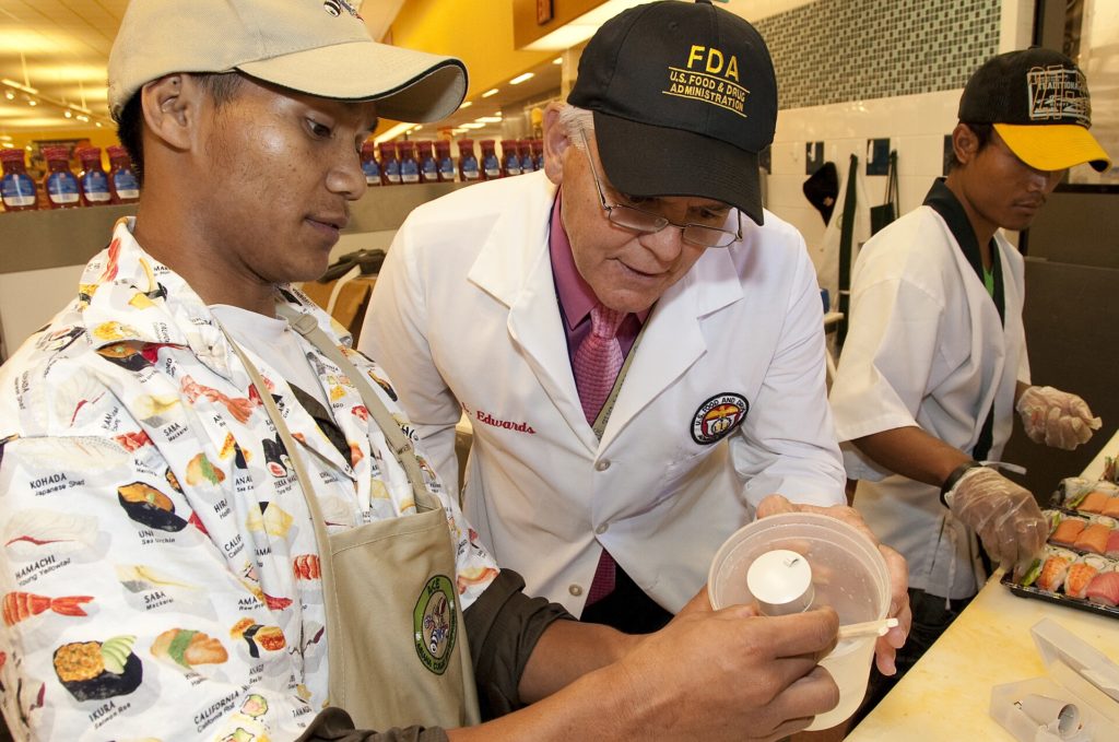 Inspector revisa alimentos en la cocina de un restaurante, como en la inspección de salud de Hendersonville