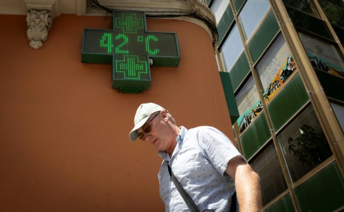 Un hombre pasa junto al cartel electrónico de una farmacia que marca 42 grados Celsius, el 20 de junio de 2026 en Palma de Mallorca, en el archipiélago español de las islas Baleares. AFP
