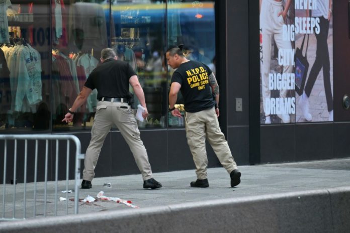 Dos policías de Nueva York trabajan en el lugar donde se produjo el apuñalamiento mortal, el 31 de agosto de 2026 cerca de Times Square. AFP