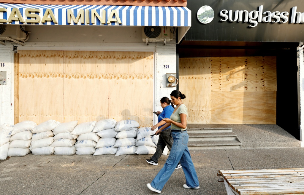 Comercio tapiado con tablones de madera y sacos de arena para protegerse del huracán Simón en Puerto Vallarta, Jalisco