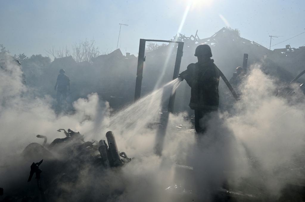 Un bombero apaga un incendio entre los escombros de viviendas destruidas por un ataque ruso con bombas aéreas en Járkov, Ucrania