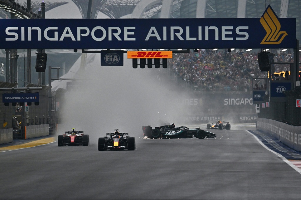 Un monoplaza gira en la recta de meta mientras otros pilotos esquivan la nube de agua en la salida del esprint del Gran Premio de Singapur
